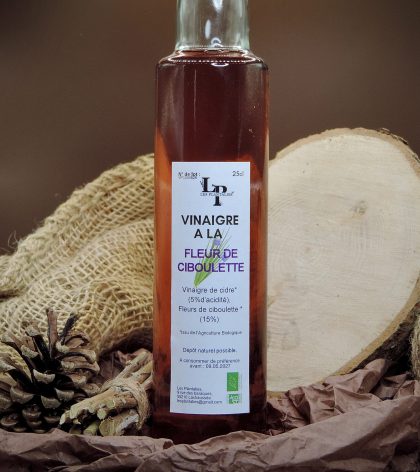 Vinaigre de cidre à la fleur de ciboulette en bouteille, condiment floral.